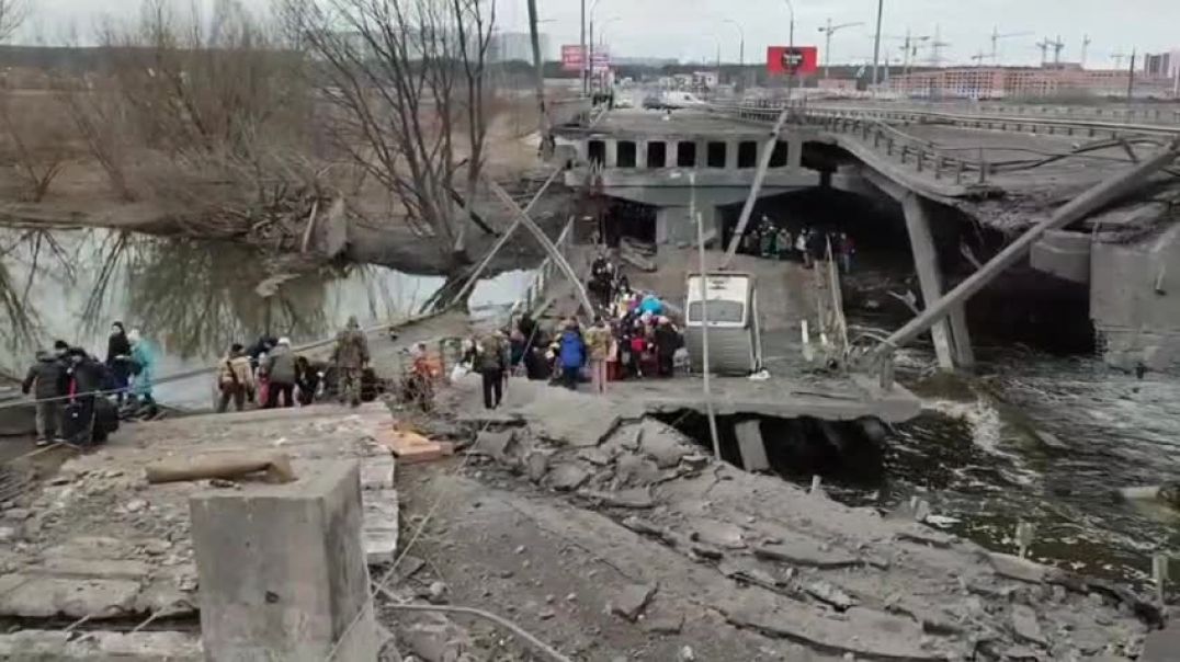 Жители Ирпеня перебираются через разрушенный мост