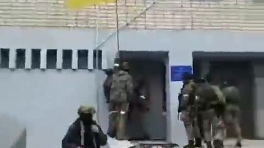 Бойцы ингушского ОМОНа снимают украинский флаг со стены административного здания СБУ Запорожской области