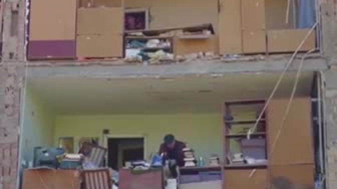 Житель Киева собирает вещи в разрушенной квартире