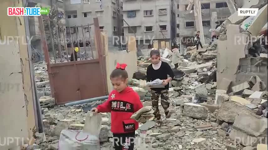 ⁣ Дети собирают уцелевшие страницы Корана на месте разрушенной мечети в Газе