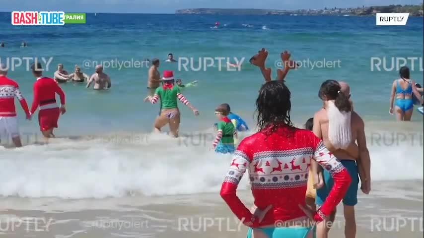 Жители австралийского Сиднея отметили Рождество на пляже, установив елку и надев праздничные шапки и костюмы