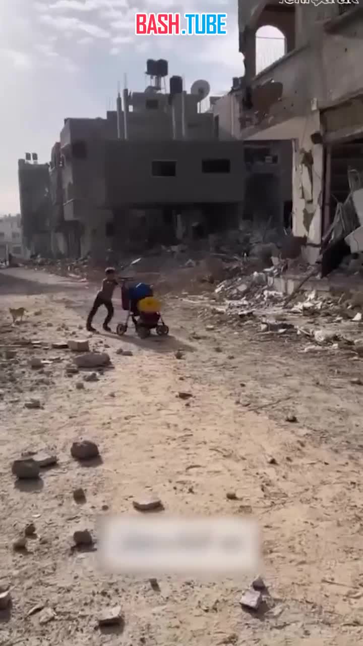 ⁣ Палестинский мальчик среди руин пытается донести коляску с водой