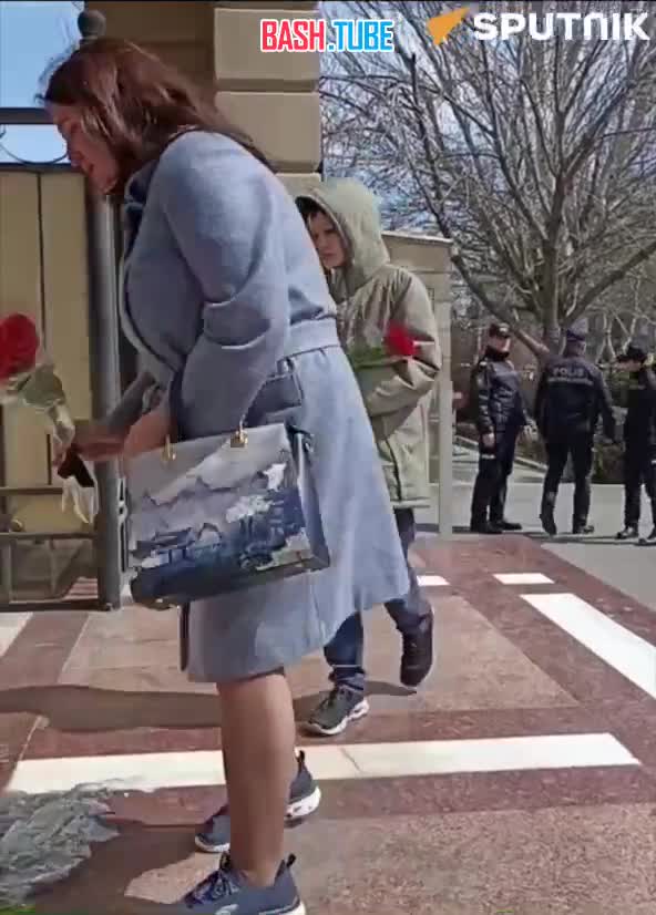 ⁣ Люди в Баку несут цветы к Посольству РФ
